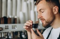 Male barista preparing coffee in a coffee house